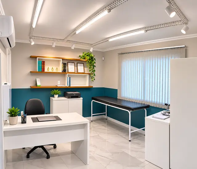 Consultório médico com mesa branca, maca, prateleiras em madeira e parede em azul petróleo